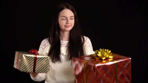 Jeune femme avec une boîte cadeau sur fond noir. coffret cadeau avec ruban blanc pour Bonne Année, Joyeux Noël, Saint Valentin, anniversaire . — Video