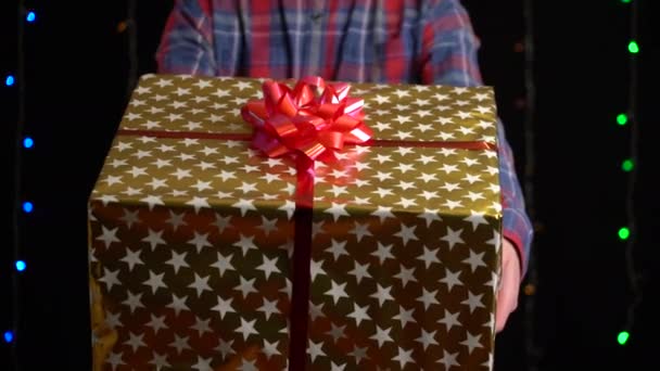 带着黑色背景礼品盒的男孩。 有彩带的礼品盒，新年快乐，圣诞快乐，情人节，生日 — 图库视频影像