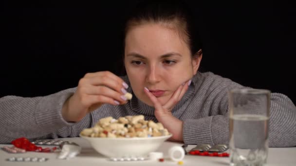 Mädchen nimmt Löffel, um Tabletten aus Schüssel zu essen, pharmazeutische Produkte — Stockvideo