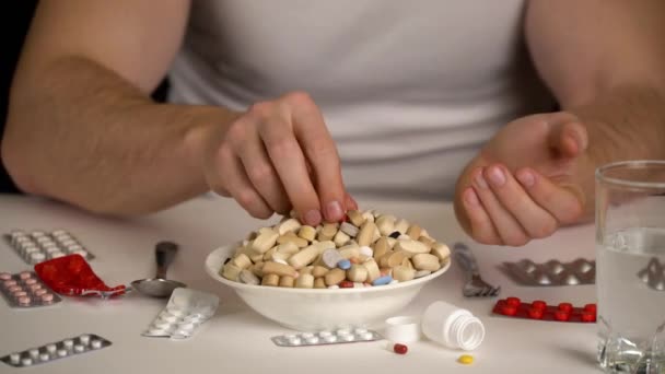 Мужчины едят таблетки из миски, фармацевтические продукты — стоковое видео