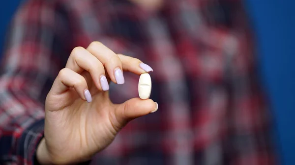 Mulher apresentando uma mão com pílulas — Fotografia de Stock