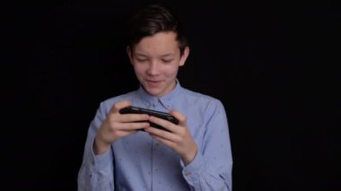 Siyah arka planda gülümseyen ve cep telefonu kullanan gençler.