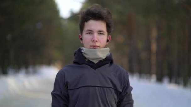 Портрет красивого молодого человека в наушниках, готового бежать — стоковое видео
