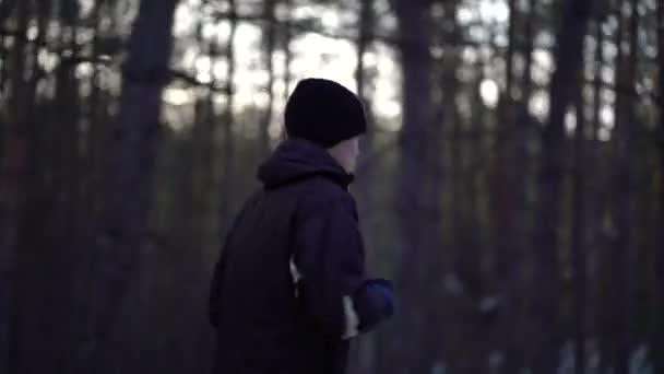 冬の森の中で若い男性アスリートジョギング — ストック動画