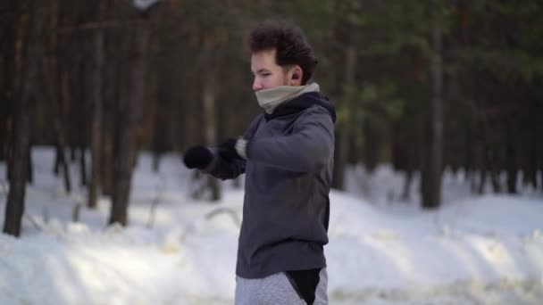 Мальчик в спортивной одежде делает упражнения на свежем воздухе в сосновом лесу. Концепция здорового образа жизни — стоковое видео