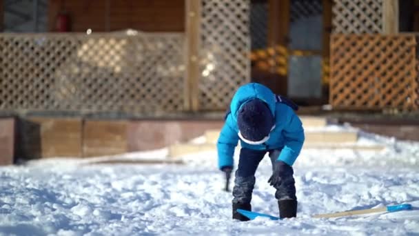 Menino limpando neve no inverno — Vídeo de Stock