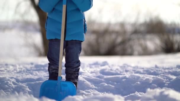 Kleiner Junge schaufelt im Winter Schnee — Stockvideo