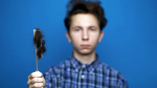 Balding problem men. Teen hand holding loss hair comb — Stock Photo, Image