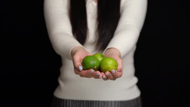Woman shows lime in hands on a black background — Stock Video