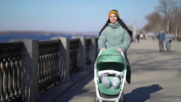 Kvinna promenader genom parken med en barnvagn — Stockvideo