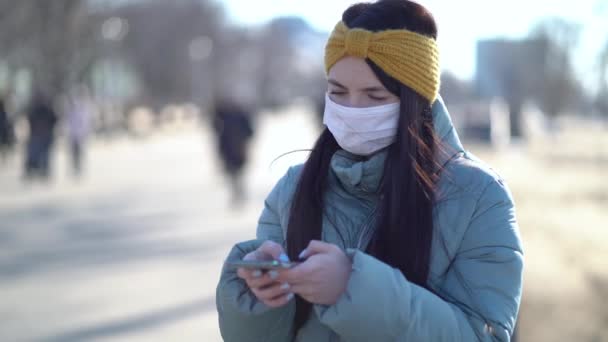 Young Woman Wearing a Mask Texting on the Smartphone — Stock Video