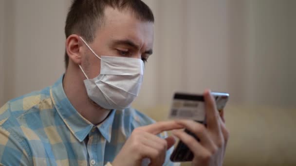 Homme avec masque shopping en ligne avec carte de crédit — Video