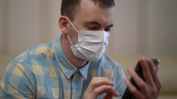Man draagt medisch masker op het werk vanuit huis — Stockvideo