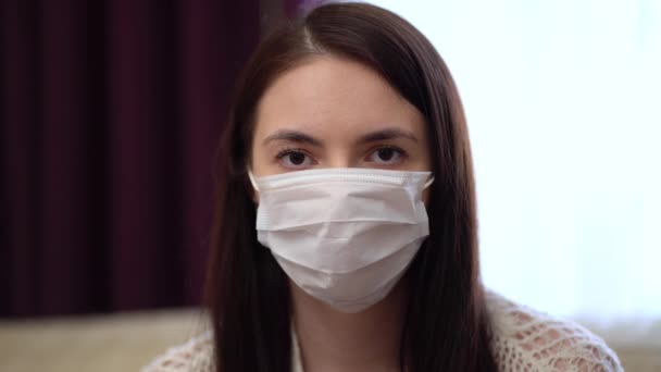 Jonge vrouw draagt thuis een beschermend masker — Stockvideo