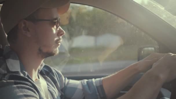 Elegante giovane guida auto attraverso la grande città soleggiata — Video Stock