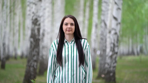 Chica camina en un bosque de abedules en un día de primavera . —  Fotos de Stock