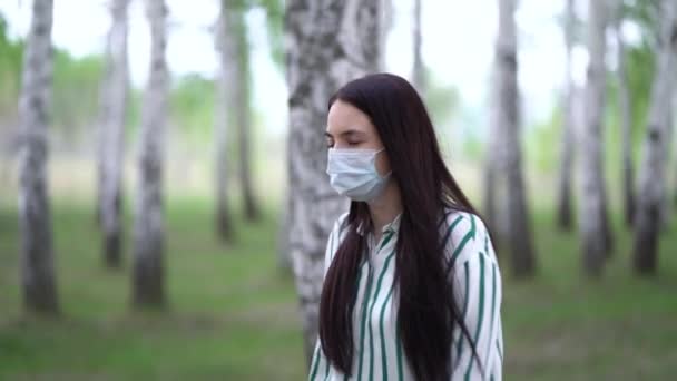 Mulher elegante em uma máscara médica em um passeio na floresta de vidoeiro — Vídeo de Stock