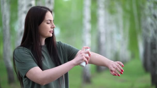 Mujer joven en un bosque de abedules pone un repelente de mosquitos en su piel . — Vídeo de stock