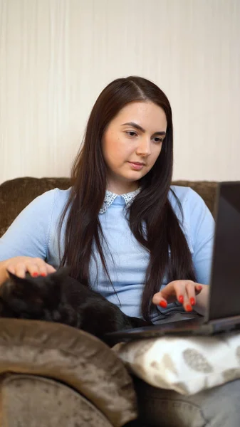 Mulher com gato preto trabalhando no computador portátil no escritório em casa — Fotografia de Stock