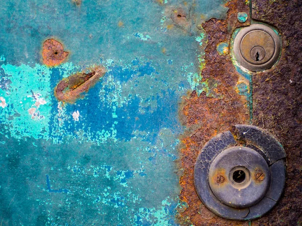 Rusty door with turquoise and blue peeling paint and rust background
