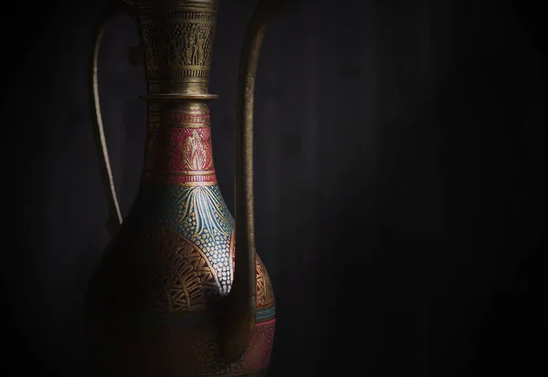 Oriental textured vessel on a dark background