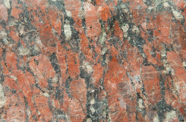 Fond de granit rouge pâle mat non poli avec une structure veineuse fine et des ajouts de couleurs noir et blanc — Photo
