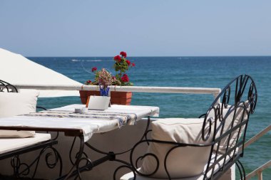 Güzel açık kafe dövme mobilya, beyaz yastıklar ve tatil beldesi Sozopol, Bulgaristan güneşli yaz günü, tente. Doğal deniz arka plan ile fotoğraf