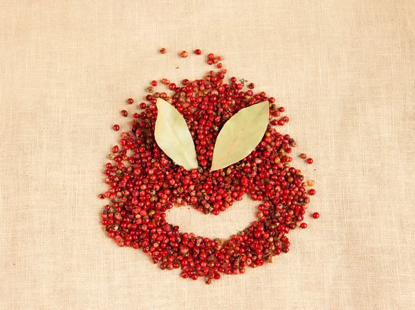 Concepto cara sonriente hecha de semillas de pimienta rosa y algunas hojas de laurel secas — Foto de Stock