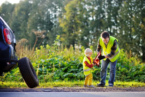 Far och hans lille son reparera bilen och byta hjul — Stockfoto