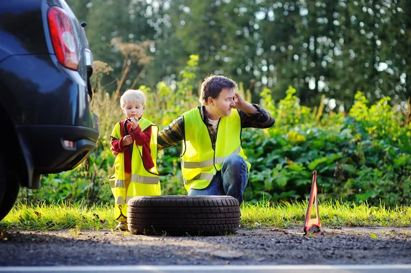 Far och hans lille son reparera bilen och byta hjul tillsammans — Stockfoto