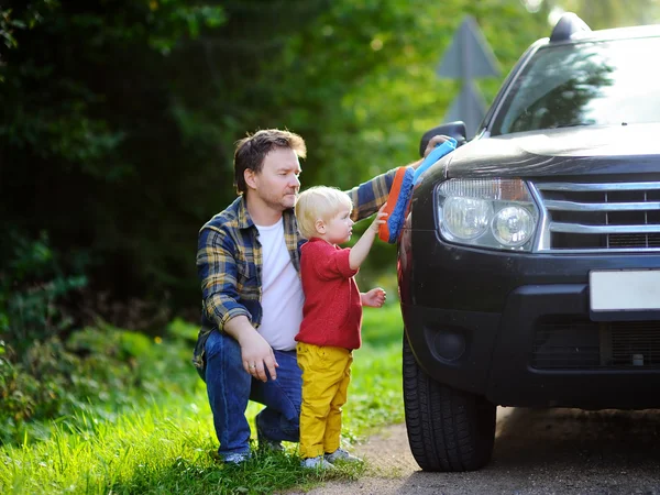 Padre con su hijo pequeño lavando el coche juntos — Foto de Stock