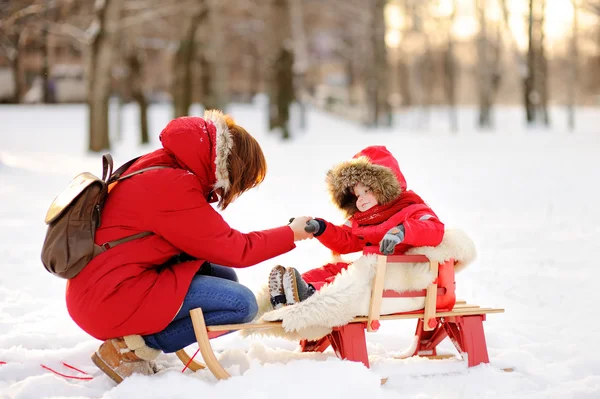 Красивий маленький хлопчик і його мати розважаються взимку — стокове фото