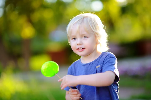 Carino bambino ragazzo con Grande verde lecca-lecca — Foto Stock