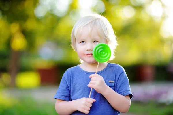 Ładny toddler chłopiec z duży zielony lizak — Zdjęcie stockowe