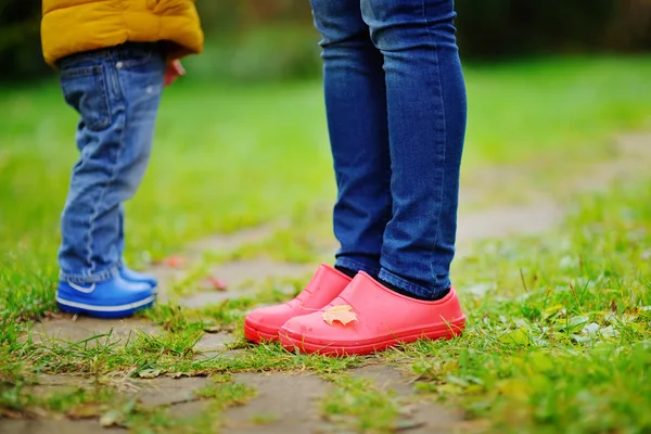 Close up photo of child and adult legs in rubber boots — Stock Photo, Image