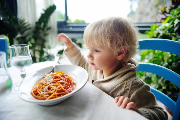 Lindo niño comiendo pasta en el restaurante interior —  Fotos de Stock