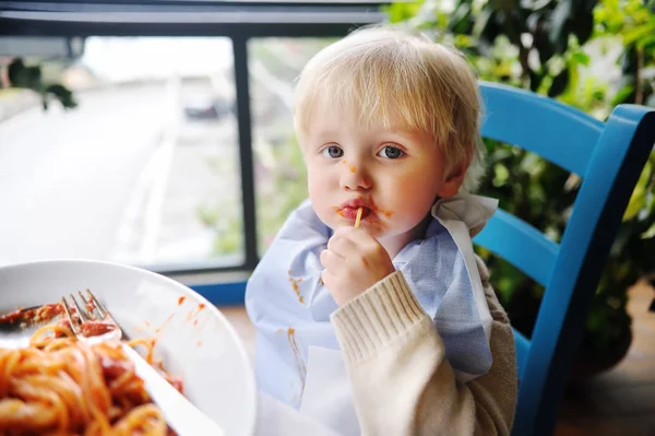 Bonito menino de criança comendo macarrão em italiano dentro de casa restaurante — Fotografia de Stock