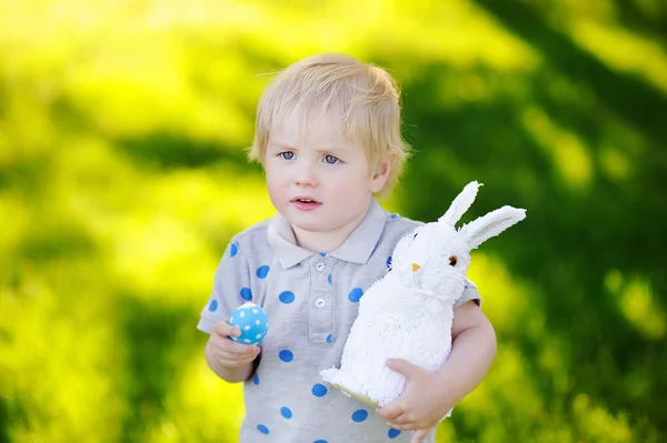 Niño cazando huevos de Pascua en el jardín de primavera el día de Pascua —  Fotos de Stock