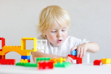 Küçük çocuk renkli plastik bloklarla oynama