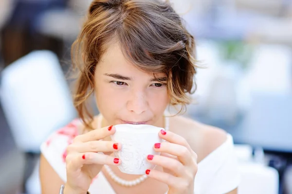 Young bride drinking coffee at the outdoors cafe — Stock Photo, Image