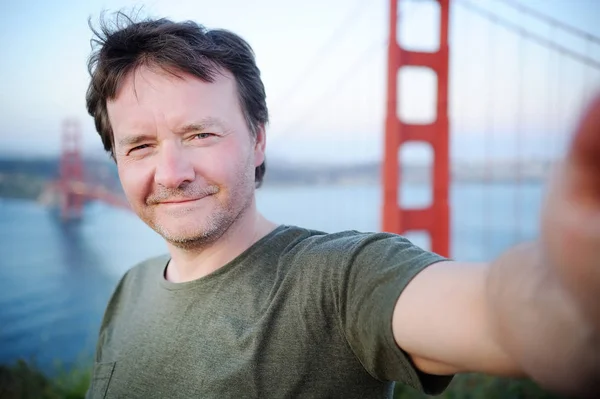 Middle age man making a self portrait with Golden Gate bridge in — Stock Photo, Image