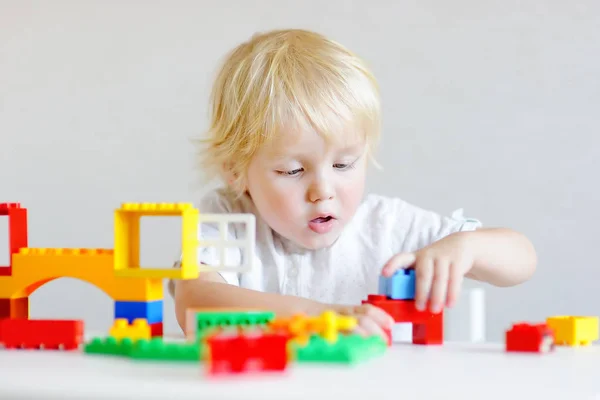 Menino brincando com blocos de plástico coloridos — Fotografia de Stock