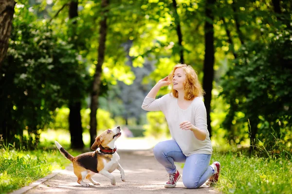 Ung vacker kvinna leker med Beagle hund — Stockfoto