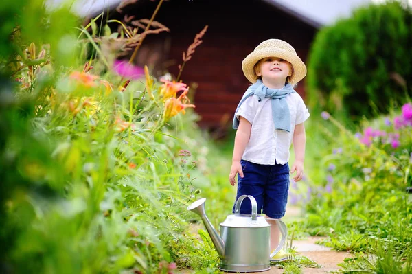 Roztomilý batole chlapec zalévání rostlin v zahradě v létě slunečný den — Stock fotografie