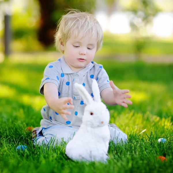Paskalya günü bahar bahçesinde Paskalya yumurtası arayan küçük bir çocuk.