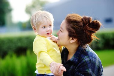 Young asian women with cute caucasian toddler boy clipart