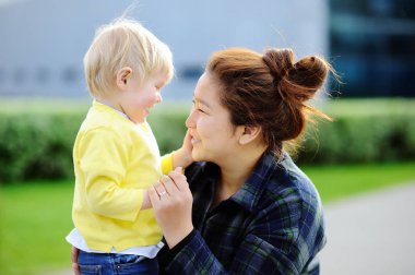 Young asian women with cute caucasian toddler boy clipart