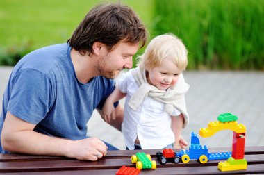 Renkli plastik bloklarla oynama yürümeye başlayan çocuk oğluyla baba