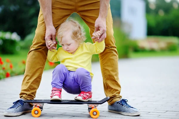 Roztomilé batole dívka učí na skateboardu se svým otcem — Stock fotografie