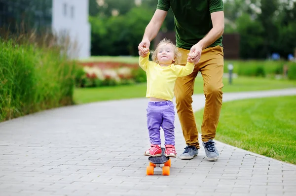 Χαριτωμένο μικρό παιδί κορίτσι Μαθαίνοντας να skateboard με τον πατέρα της — Φωτογραφία Αρχείου